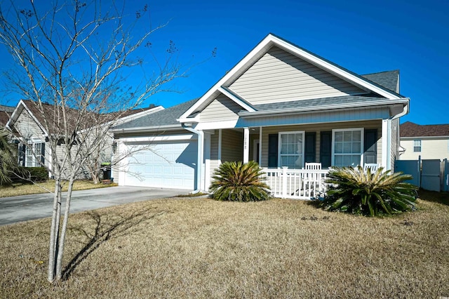 view of front of home with a garage, a front lawn, and covered porch