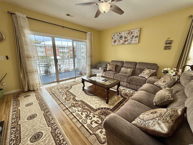 living room featuring wood-type flooring and ceiling fan