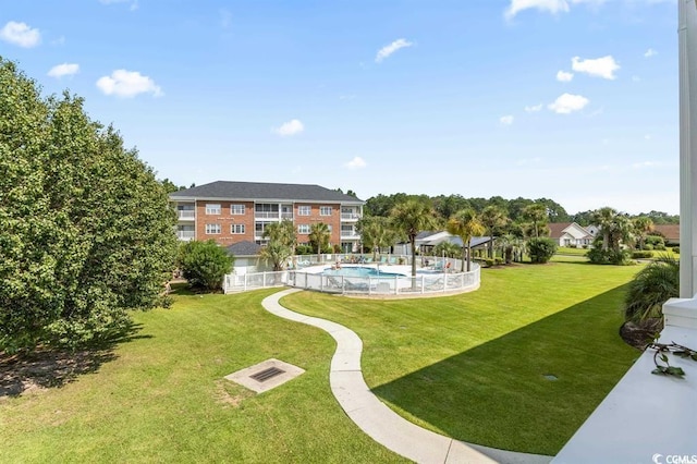 view of home's community featuring a pool and a lawn