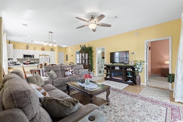 living room with ceiling fan and light hardwood / wood-style floors