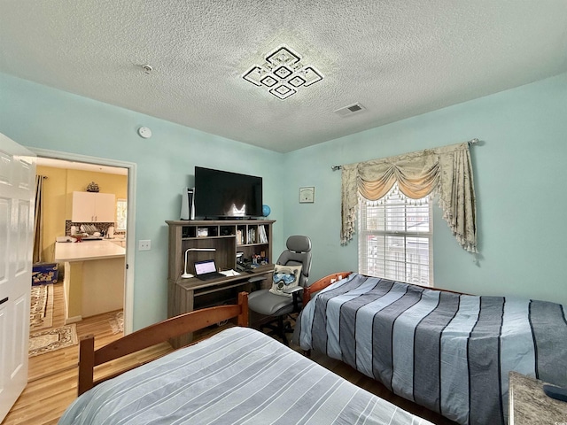 bedroom featuring hardwood / wood-style floors and a textured ceiling