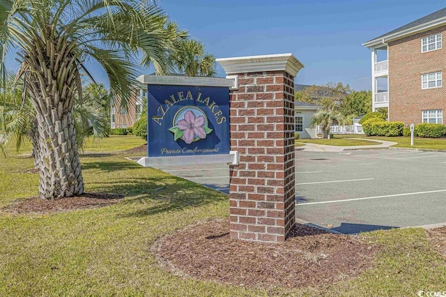 community / neighborhood sign featuring a yard