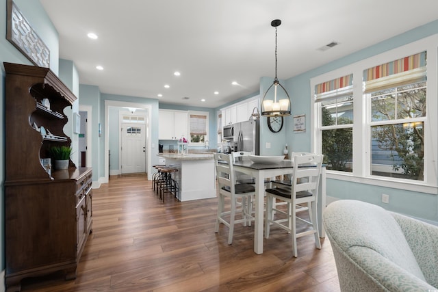 dining area with a notable chandelier and dark wood-type flooring