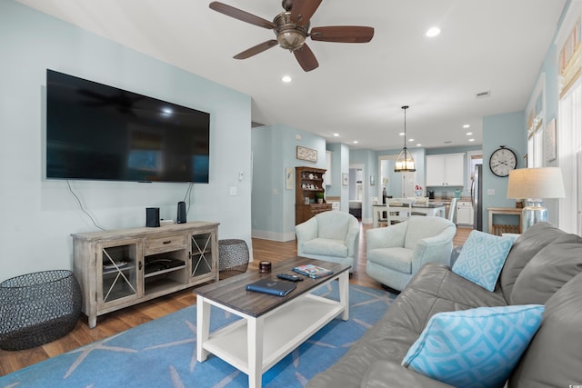 living room with ceiling fan and hardwood / wood-style floors