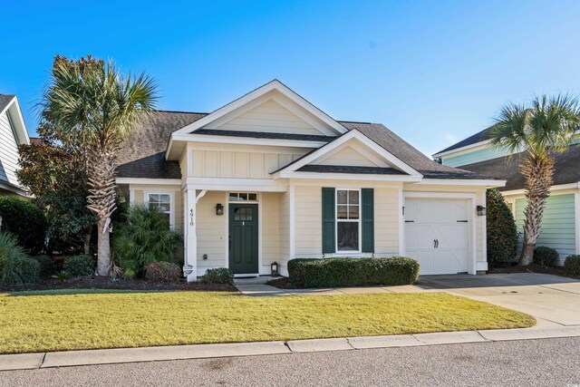 view of front of home with a garage and a front lawn