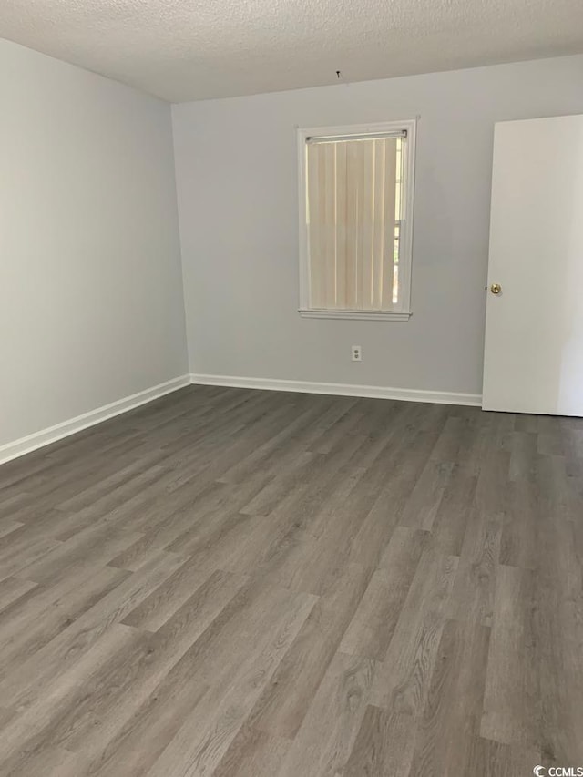 spare room with wood-type flooring and a textured ceiling