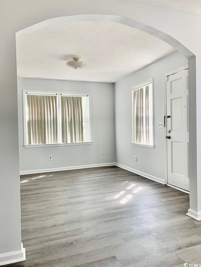 entrance foyer with hardwood / wood-style floors and a textured ceiling