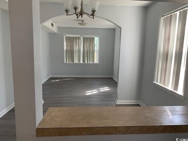 unfurnished room with dark hardwood / wood-style floors and a chandelier