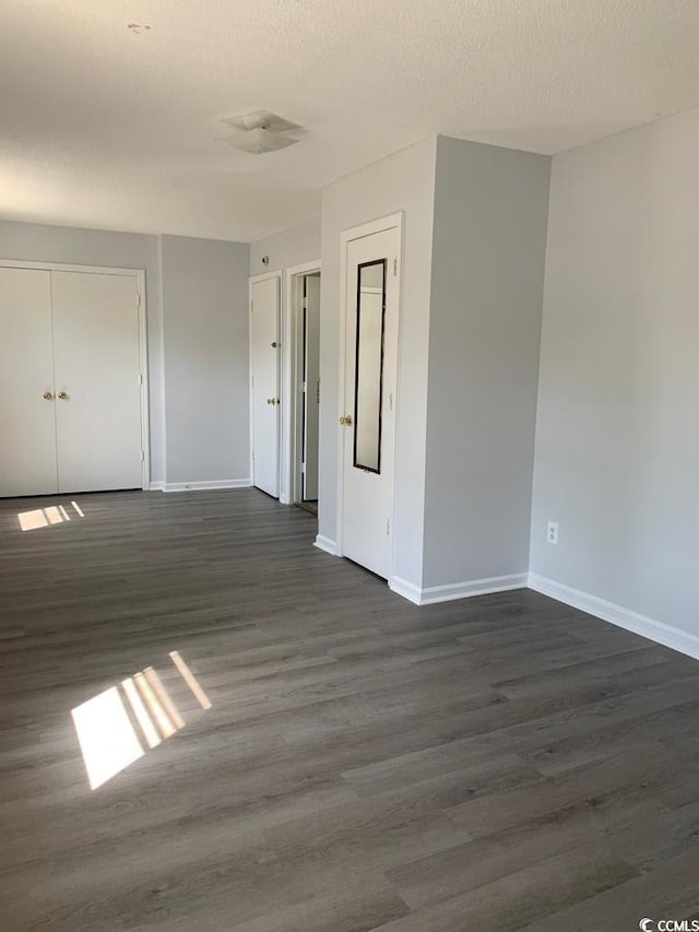 empty room featuring dark wood-type flooring and a textured ceiling