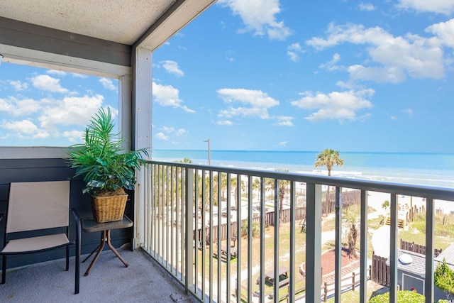 balcony featuring a water view and a view of the beach