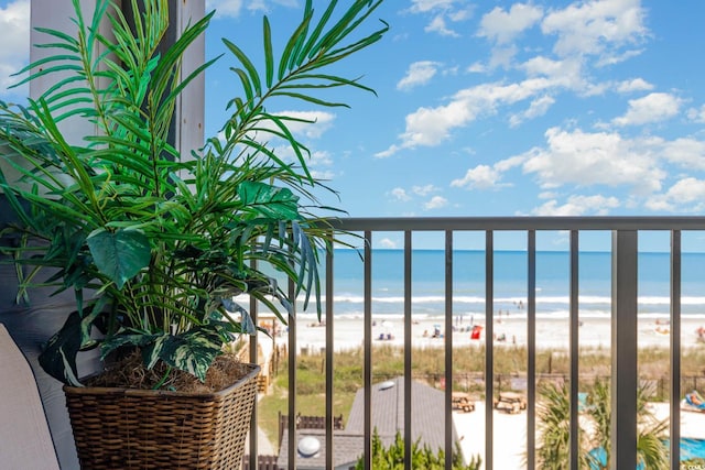 balcony featuring a water view and a beach view