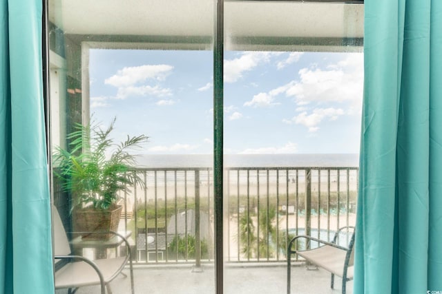 balcony featuring a view of the beach and a water view