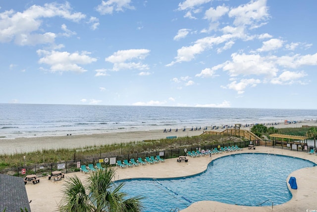 exterior space with a water view, a patio area, and a view of the beach