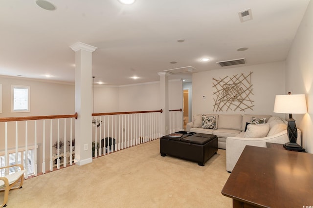 carpeted living room featuring crown molding and ornate columns