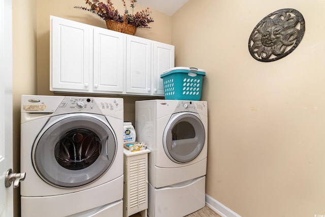 washroom featuring cabinets and washing machine and clothes dryer