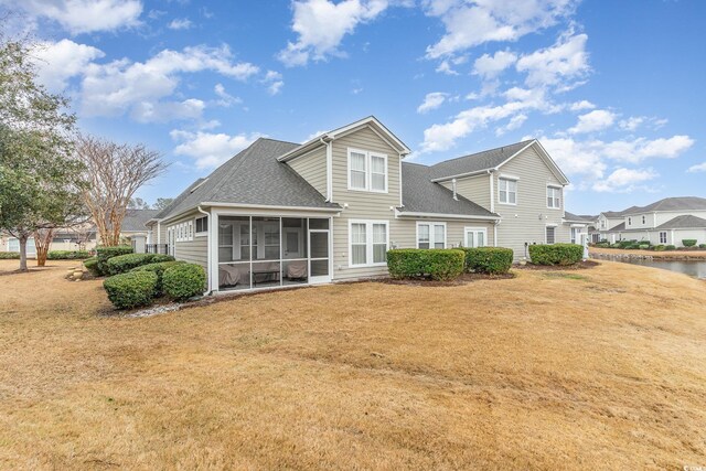 back of property with a lawn and a sunroom