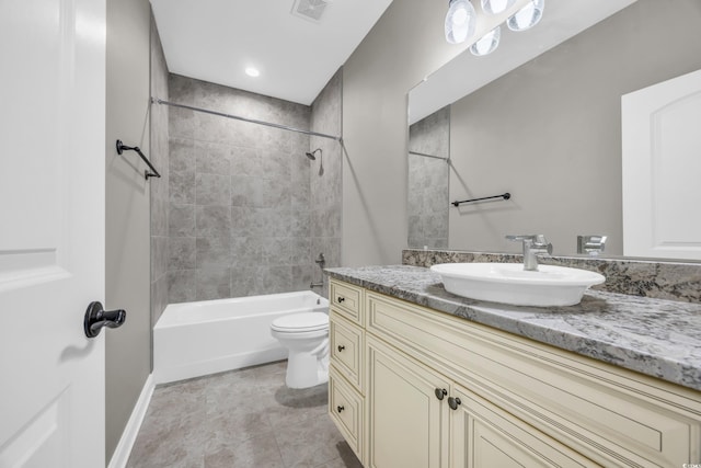 full bathroom featuring tiled shower / bath, vanity, and toilet