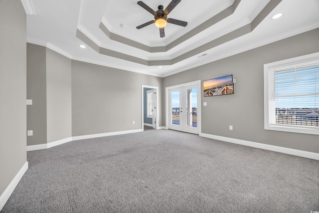 carpeted spare room featuring ceiling fan, ornamental molding, french doors, and a raised ceiling