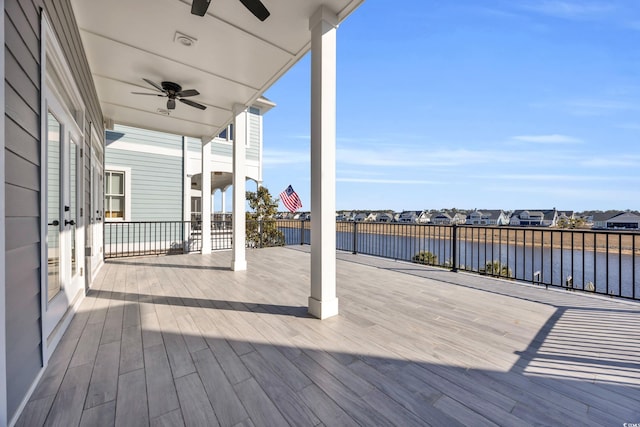 wooden terrace featuring a water view and ceiling fan