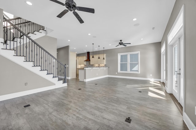 unfurnished living room with wood-type flooring and ceiling fan