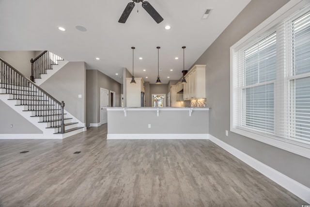 unfurnished living room featuring hardwood / wood-style flooring and ceiling fan