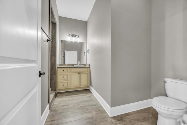 bathroom featuring vanity, toilet, and a shower