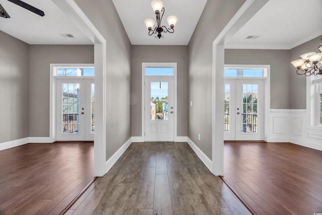 entryway featuring french doors, a chandelier, and dark wood-type flooring