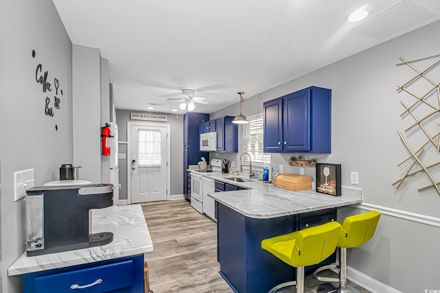 kitchen with a kitchen breakfast bar, hanging light fixtures, kitchen peninsula, blue cabinetry, and white appliances