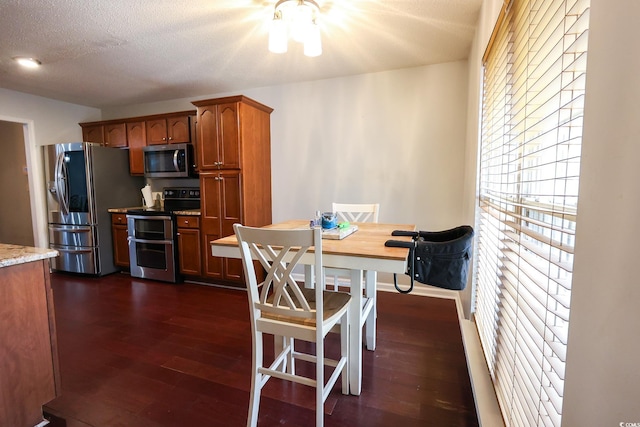 kitchen featuring dark hardwood / wood-style flooring, a textured ceiling, and appliances with stainless steel finishes