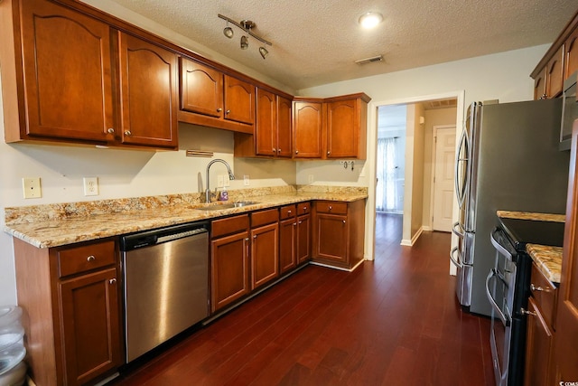 kitchen with stainless steel appliances, dark hardwood / wood-style flooring, sink, and a textured ceiling