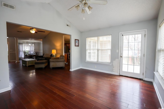 living room with ceiling fan with notable chandelier, dark wood-type flooring, and high vaulted ceiling