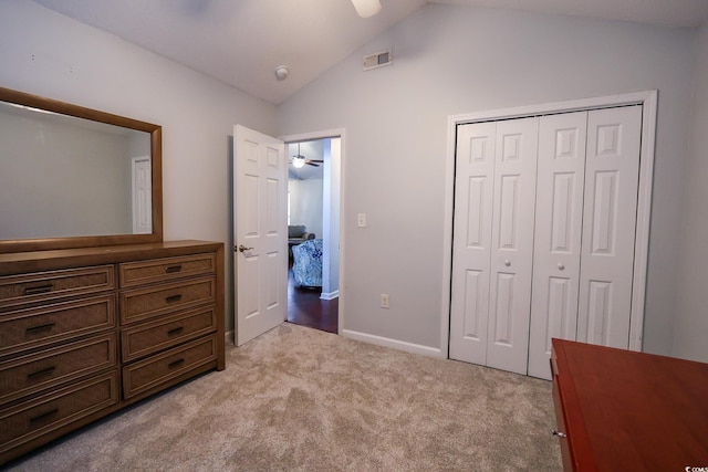 carpeted bedroom featuring vaulted ceiling and a closet