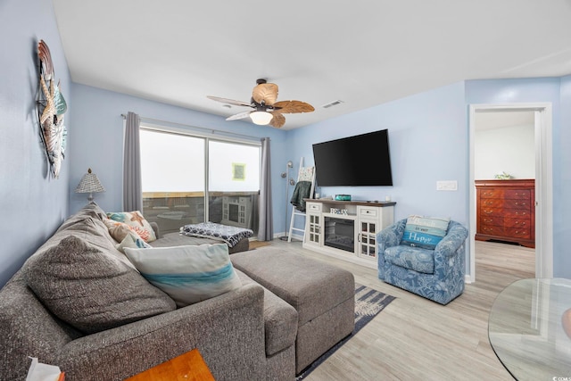 living room with light hardwood / wood-style flooring and ceiling fan