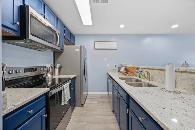 kitchen featuring blue cabinetry, stainless steel appliances, sink, and light stone counters