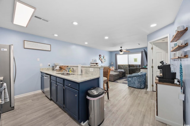 kitchen featuring sink, light hardwood / wood-style flooring, appliances with stainless steel finishes, light stone counters, and kitchen peninsula