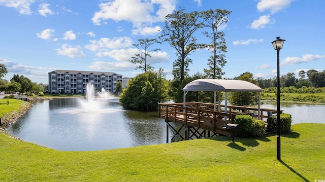 view of dock with a water view and a yard