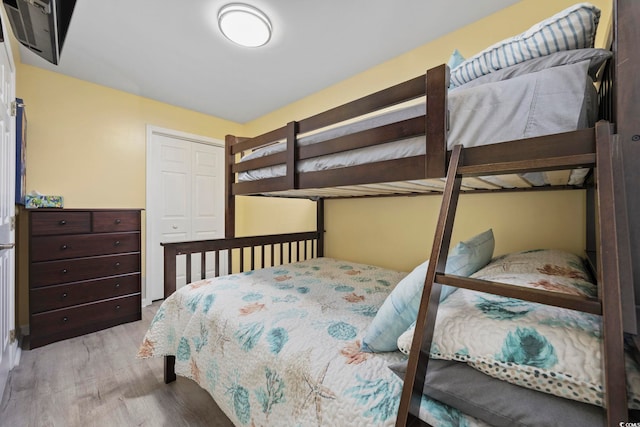 bedroom with light hardwood / wood-style floors and a closet