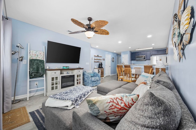 living room with ceiling fan and light hardwood / wood-style flooring