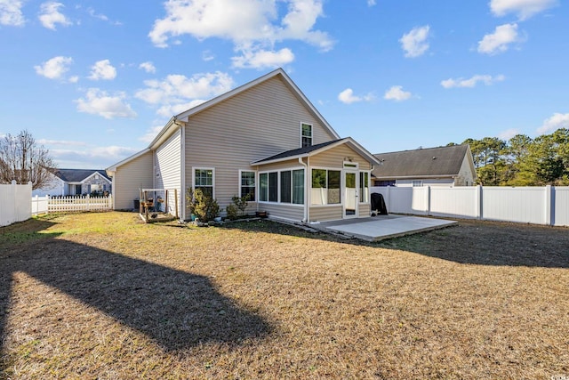 back of property featuring a yard, a sunroom, and a patio