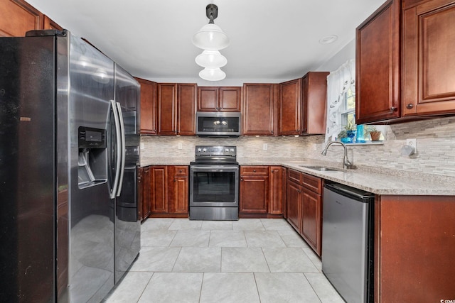 kitchen featuring light tile patterned flooring, sink, decorative light fixtures, appliances with stainless steel finishes, and backsplash