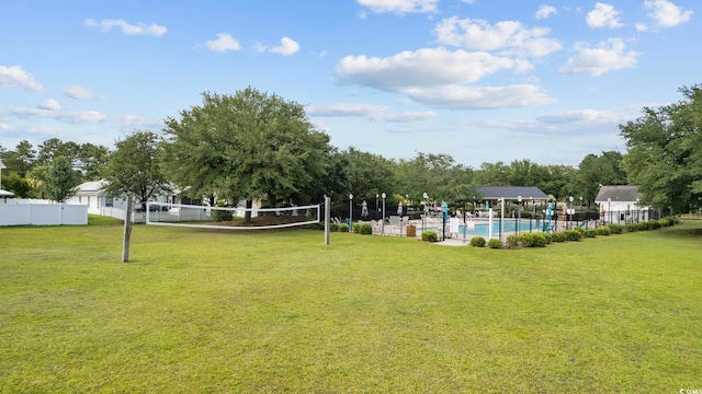 view of home's community featuring a pool, a lawn, and volleyball court