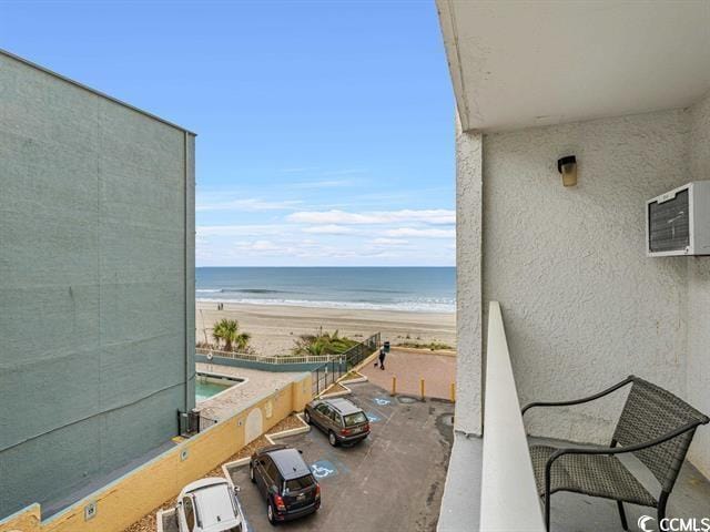 balcony featuring a water view and a view of the beach