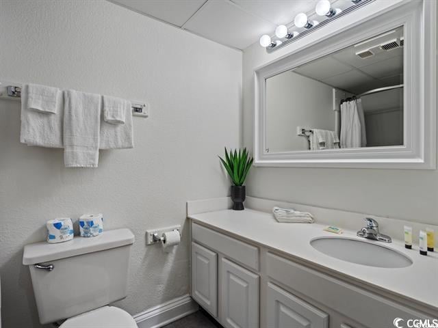 bathroom with a shower with curtain, vanity, and toilet