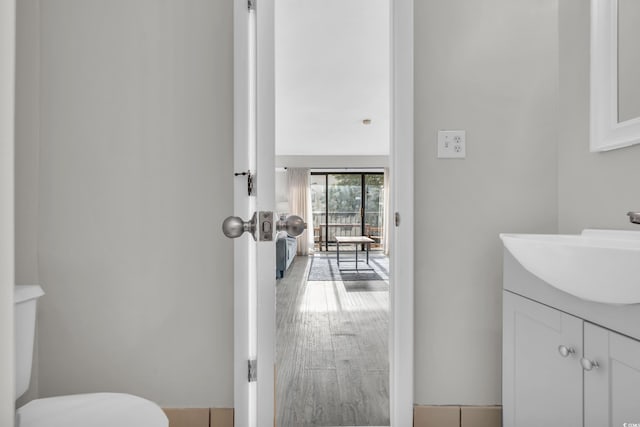 bathroom featuring wood-type flooring, vanity, and toilet