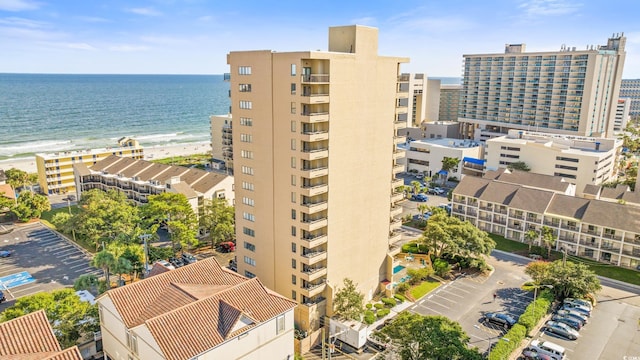 view of building exterior with a water view and a view of the beach