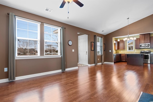 unfurnished living room featuring lofted ceiling, dark hardwood / wood-style floors, and ceiling fan with notable chandelier