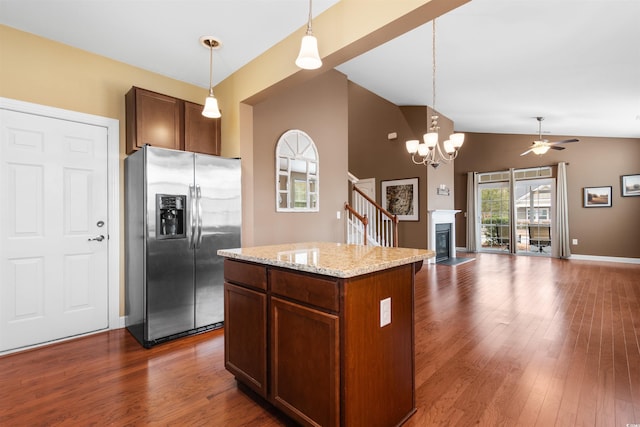 kitchen with pendant lighting, a kitchen island, lofted ceiling, and stainless steel refrigerator with ice dispenser