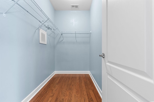 walk in closet with wood-type flooring