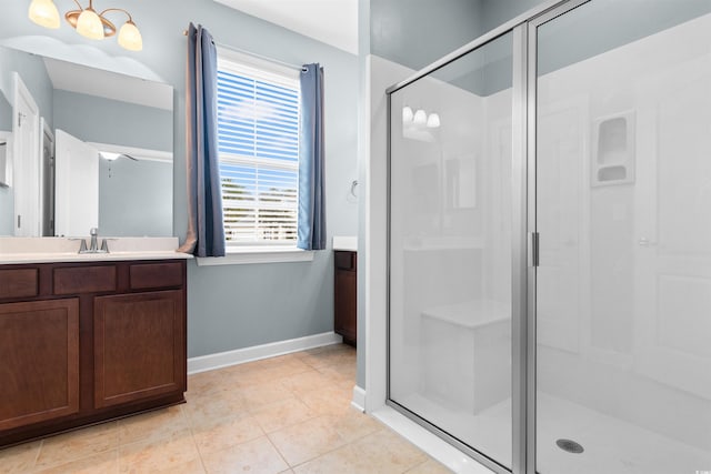 bathroom with vanity, plenty of natural light, tile patterned floors, and a shower with shower door