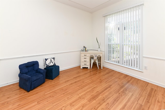 living area with a healthy amount of sunlight and light hardwood / wood-style flooring